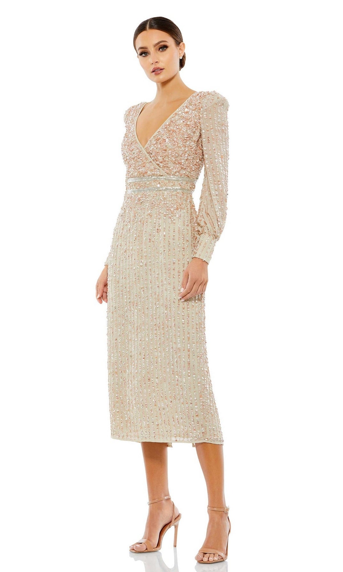 A woman models the Mac Duggal 93593 knee-length wedding guest dress, a beige, long-sleeve, sequin-embellished semi-formal outfit with a V-neckline and nude heels, standing against a white background.